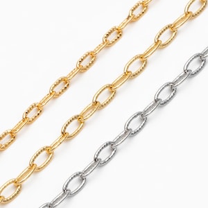 Puede incluir: Tres cadenas doradas de diferentes longitudes y grosores, todas con un diseño de eslabón ovalado texturizado.