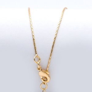 Puede incluir: Un collar de cadena de oro con cierre de langosta.