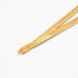 May include: A gold chain necklace with a snake chain design.