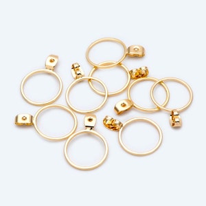 May include: A set of eight gold-toned metal pendant bails with circular openings. The bails have a loop at the top for attaching to a chain or cord.