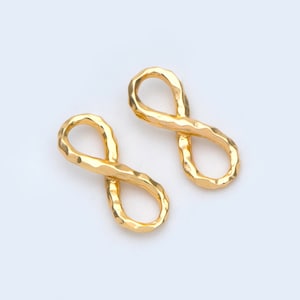 Peut inclure: Une paire de boucles d'oreilles en forme d'infini en or avec une finition texturée.