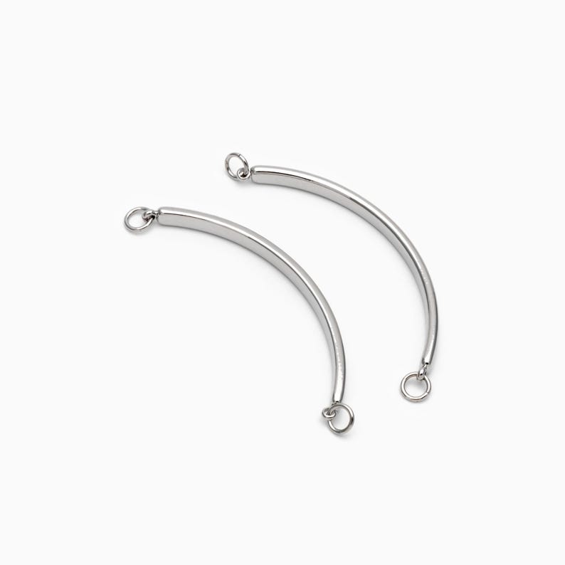 May include: Two silver metal curved connector pieces with jump rings at each end.