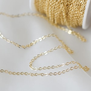 May include: A close-up of a gold chain, a popular jewelry making supply. The chain is delicate and has a fine, oval-shaped link.