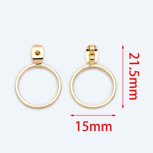 May include: A pair of gold-tone hoop earrings with a diameter of 15mm and a height of 21.5mm.