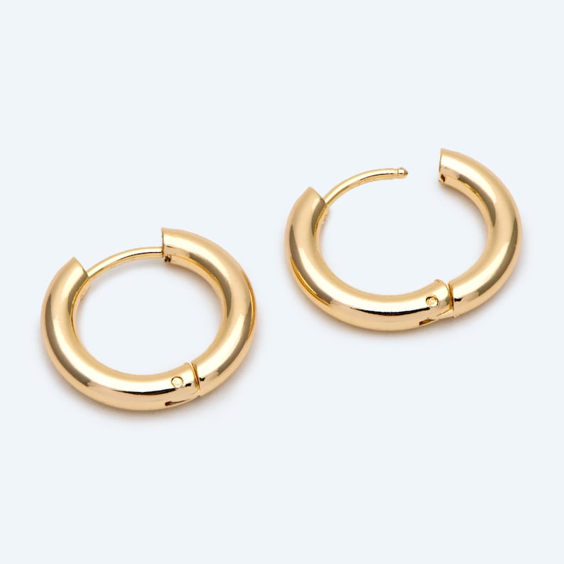 May include: A pair of gold hoop earrings. The earrings are simple and classic, with a smooth, polished finish.