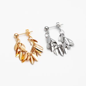 May include: A pair of earrings with a delicate chain and multiple leaf-shaped charms. One earring is gold and the other is silver.