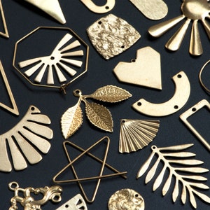 May include: Assortment of gold-toned metal shapes and designs, including leaves, stars, hearts, and geometric shapes. These metal pieces are perfect for crafting jewelry or other decorative projects.