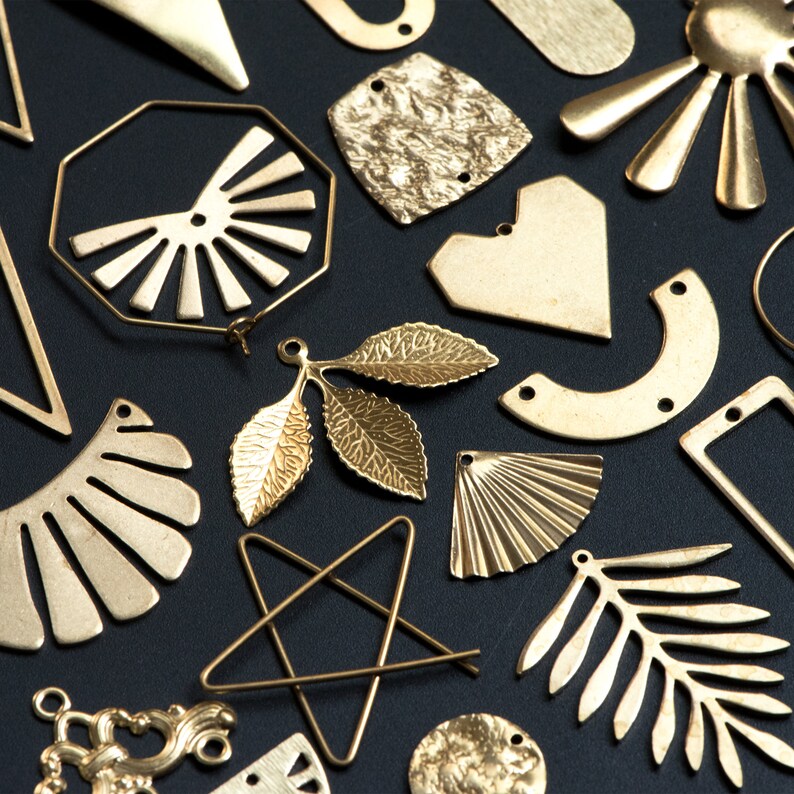 May include: Assortment of gold-toned metal shapes and designs, including leaves, stars, hearts, and geometric shapes. These metal pieces are perfect for crafting jewelry or other decorative projects.