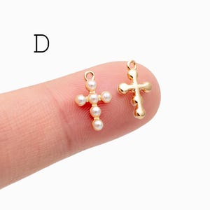 Pu&ograve; includere: Due ciondoli a forma di croce color oro. Una croce presenta un design a perle, mentre l'altra ha un aspetto liscio e arrotondato. I ciondoli sono piccoli e adatti per la creazione di gioielli o progetti di artigianato.