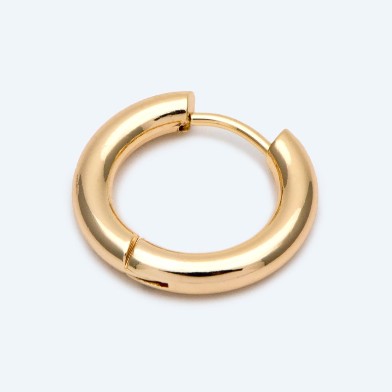 May include: A gold hoop earring with a smooth, polished finish.