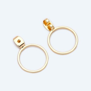 Op de afbeelding: Een paar gouden creolen met een eenvoudig, rond ontwerp. De oorbellen zijn gemaakt van metaal en hebben een gladde afwerking.