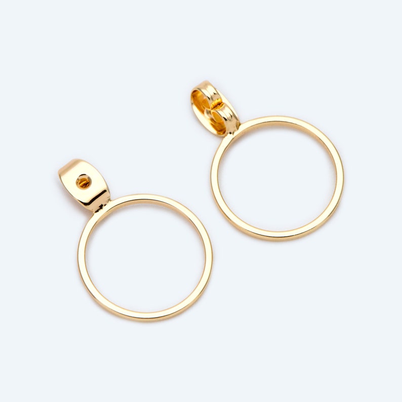 May include: A pair of gold hoop earrings with a simple, circular design. The earrings are made of metal and have a smooth finish.
