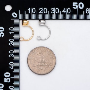 May include: Two hoop earrings, one gold and one silver, are shown next to a US quarter. The earrings are about the size of a quarter.