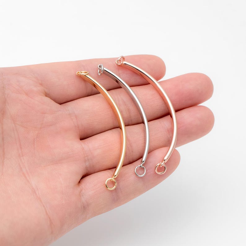 May include: Three metal bangle bracelet blanks in gold, silver, and rose gold. Each blank has a small loop on each end.