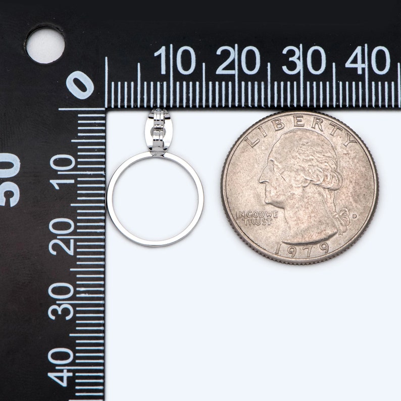 May include: A silver ring with a small row of diamonds on the band. The ring is shown next to a US quarter for size comparison.
