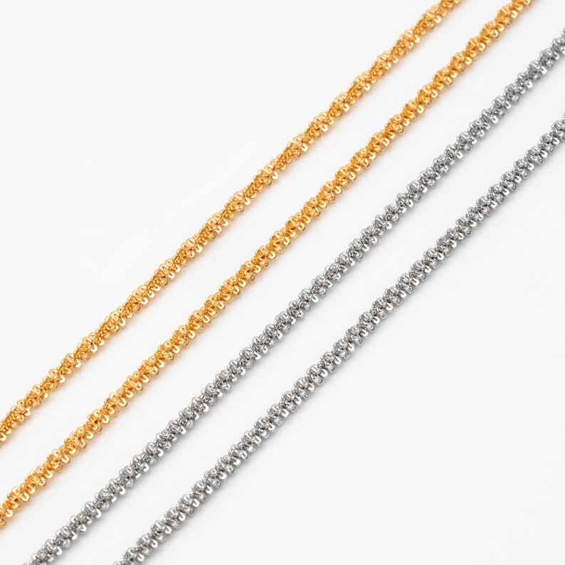 Peut inclure: Gros plan sur trois d&eacute;licats colliers en cha&icirc;ne. Deux sont de couleur argent&eacute;e et un est de couleur dor&eacute;e. Les cha&icirc;nes ont un design torsad&eacute; en forme de corde et sont pos&eacute;es sur un fond blanc. Les cha&icirc;nes sont inclin&eacute;es en diagonale.
