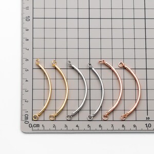 May include: Five metal jump rings in different finishes: gold, silver, rose gold, and two silver. The rings are approximately 3 cm long and have a slight curve.