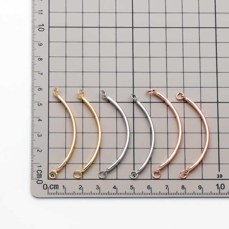 May include: Five metal jump rings in different finishes: gold, silver, rose gold, and two silver. The rings are approximately 3 cm long and have a slight curve.