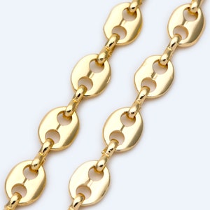 Puede incluir: Primer plano de dos collares de cadena dorados. Las cadenas presentan una serie de eslabones de forma ovalada conectados por eslabones más pequeños y rectangulares. Las cadenas están sobre un fondo blanco, resaltando la superficie brillante y reflectante del oro.