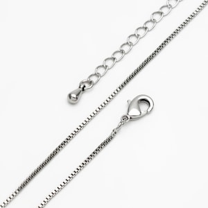 Puede incluir: Un collar de cadena de plata con cierre de langosta y una peque&ntilde;a cadena de extensi&oacute;n.
