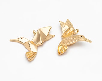 May include: Two gold-colored hummingbird charms. One charm is a geometric origami style and the other is a more traditional design with a textured surface.