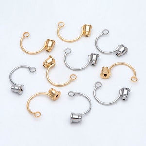 May include: A collection of gold and silver metal jewelry findings with a curved shape and a small round cap on one end. The findings are ideal for making necklaces, bracelets, and earrings.