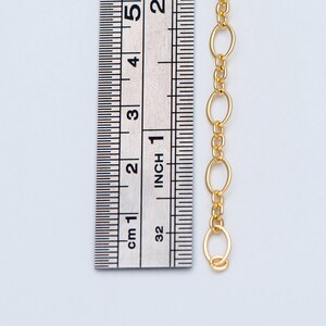 May include: Gold chain with oval links, measured against a ruler showing 1 inch.