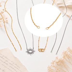 May include: A collection of gold and silver-toned necklaces, including a silver sunburst pendant with clear stones and a gold-toned chain with two interlocking rings. A circular inset highlights the gold chain links and open jump ring ends.