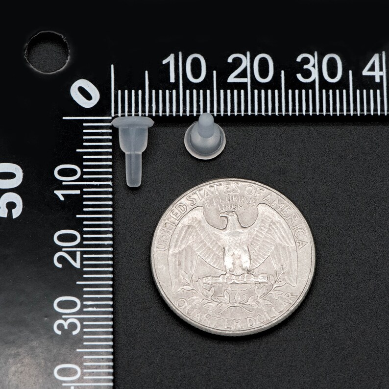 May include: Two clear plastic push-in fasteners, one with a round head and one with a pointed head, are shown next to a US quarter for size comparison.