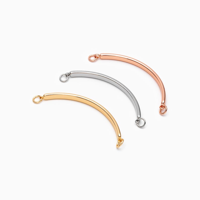 May include: Three curved metal connector pieces in gold, silver, and rose gold.