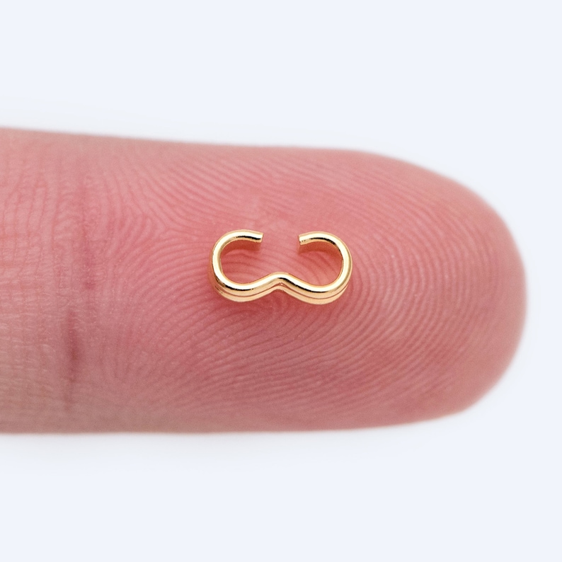 May include: Gold-toned metal jewelry clasp, also known as a jump ring, for attaching jewelry pieces together.