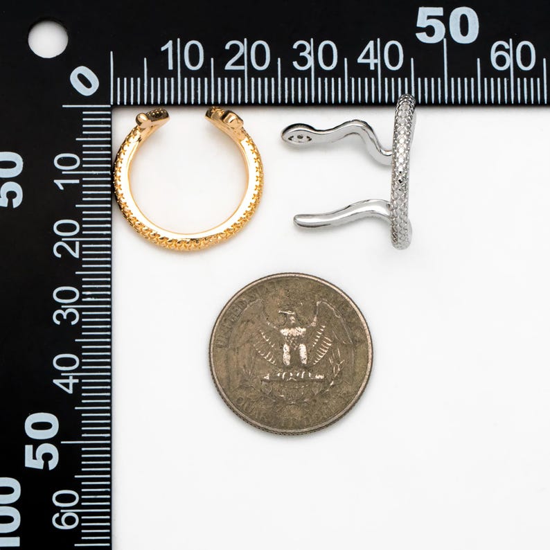 May include: Two gold and silver ear cuffs with a textured surface. The ear cuffs are next to a US quarter for size comparison.