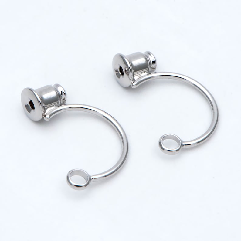 May include: Two silver-toned metal earring hooks with a small loop at the end of each hook. The hooks are designed to hold a charm or pendant.