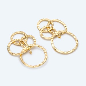 Peut inclure: Une paire de boucles d'oreilles dorées avec trois cercles entrelacés. Les cercles sont texturés et ont une finition martelée.