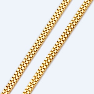 Puede incluir: Un collar de cadena de oro con un diseño de cadena de caja. La cadena está hecha de pequeños eslabones cuadrados.