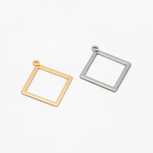 May include: Two square-shaped metal pendant charms, one gold and one silver, with a loop at the top for attaching to jewellery.