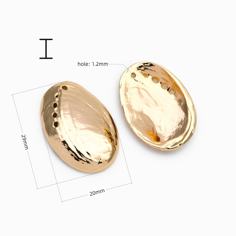 May include: Two gold-toned, oval-shaped shell charms with a metallic finish. Each piece measures 29mm in length and 20mm in width, featuring a series of small holes along one edge and a 1.2mm hole at the top for attachment.