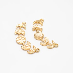 May include: Two gold-toned metal charms featuring moon phases and a crescent moon design. The charms are perfect for jewelry making or adding a touch of celestial style to crafts.