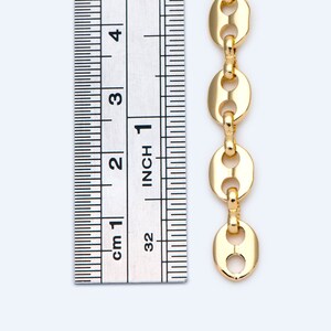 May include: A gold-colored chain with oval links, shown next to a ruler. The chain is approximately 4 inches long. The ruler displays both inches and centimeters for measurement. The chain links have a polished finish and are connected by small, round connectors.