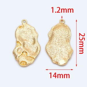 May include: Two gold-tone metal pendant charms with a textured, irregular oval shape. Each charm measures 1.2 inches in length and 1.4 inches in width.