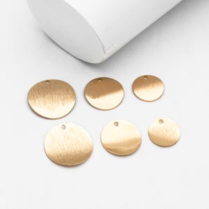 May include: Six gold-colored metal circles with a hole in the center. The circles are different sizes and have a brushed finish.