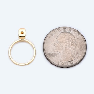 May include: A gold-toned pendant with a circular design. The pendant is about the size of a UK 20 pence coin.