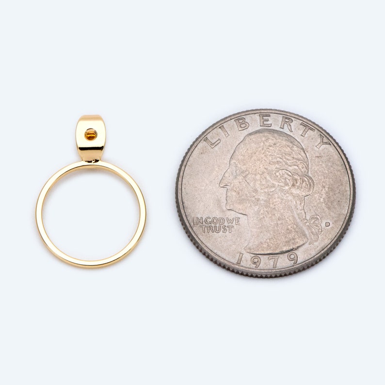 May include: A gold-toned pendant with a circular design. The pendant is about the size of a UK 20 pence coin.