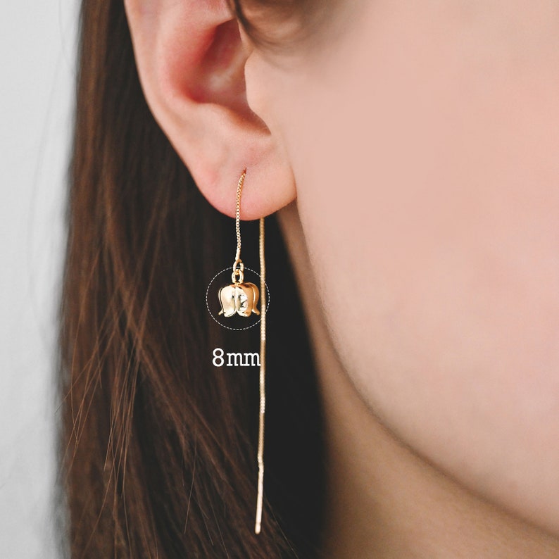 May include: Gold flower dangle earrings with a thin chain. The flower is 8mm in diameter.