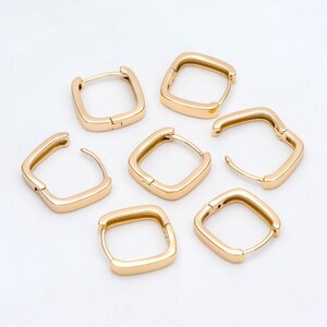 Pu&ograve; includere: Sei orecchini a cerchio quadrati in oro con chiusura a cerniera. Gli orecchini sono disposti a semicerchio su uno sfondo bianco.