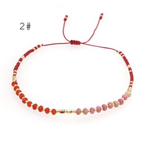 May include: Red and pink gemstone bracelet with gold beads and a red string closure. 2#