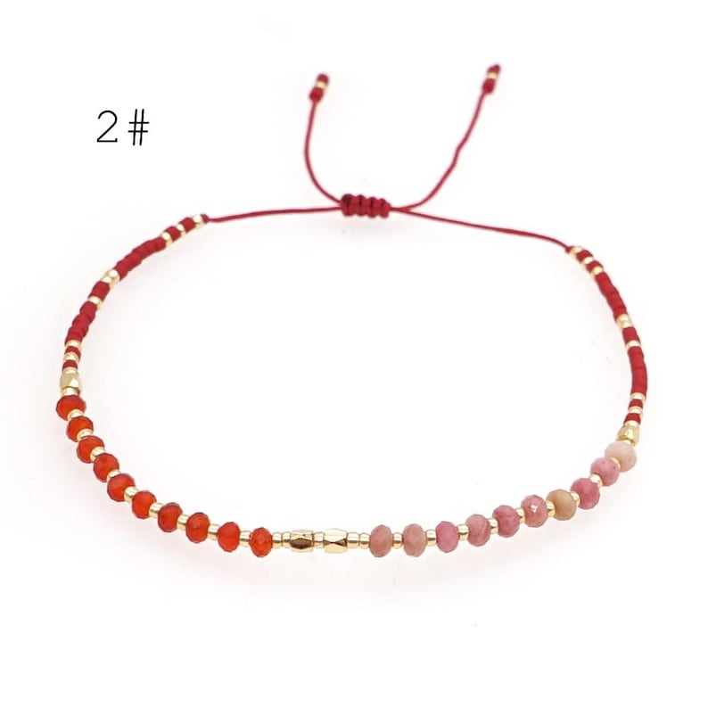 May include: Red and pink gemstone bracelet with gold beads and a red string closure. 2#