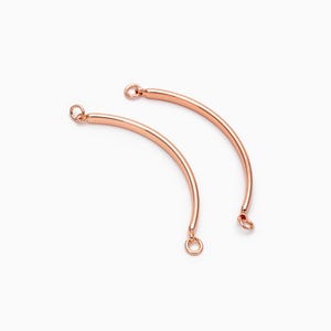 May include: Two rose gold curved connector pieces with jump rings at each end. These connectors are ideal for adding a touch of elegance to jewelry projects.