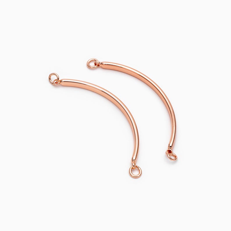 May include: Two rose gold curved connector pieces with jump rings at each end. These connectors are ideal for adding a touch of elegance to jewelry projects.