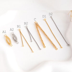 May include: Assortment of gold and silver chain extenders for jewelry making.  The extenders are labeled A1, A2, B1, B2, C, D1, and D2.